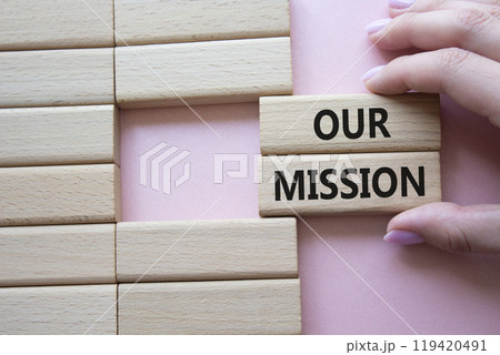 Our Mission symbol. Concept word Our Mission on wooden blocks. Businessman hand. Beautiful pink background. Business and Our Mission concept. Copy space 119420491