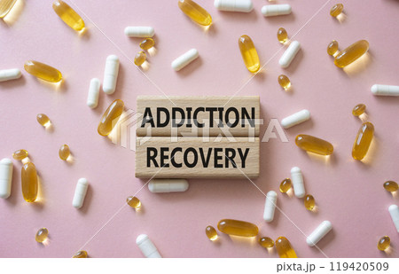 Addiction Recovery symbol. Concept words Addiction Recovery on wooden blocks. Beautiful pink background with pills. Medicine and Addiction Recovery concept. Copy space. Addiction Recovery symbol. Concept words Addiction Recovery on wooden blocks. Beautiful pink background with pills. Medicine and Addiction Recovery concept. Copy space. 119420509
