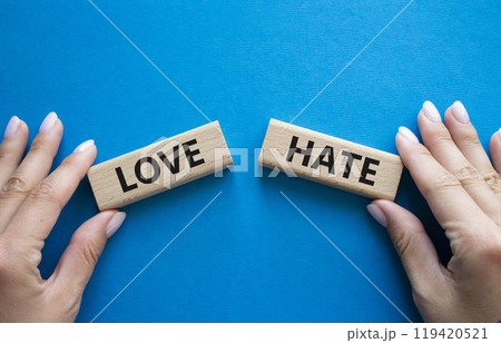 Love vs Hate symbol. Concept word Love vs Hate on wooden blocks. Businessman hand. Beautiful blue background. Business and Love vs Hate concept. Copy space Love vs Hate symbol. Concept word Love vs Hate on wooden blocks. Businessman hand. Beautiful blue background. Business and Love vs Hate concept. Copy space 119420521