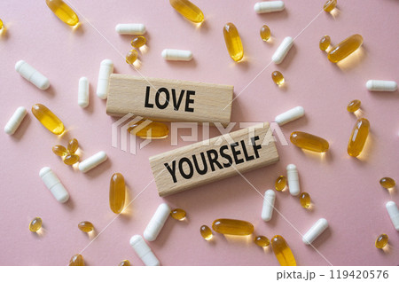 Love Yourself symbol. Concept words Love Yourself on wooden blocks. Beautiful pink background with pills. Mindfulness and Love Yourself concept. Copy space. Love Yourself symbol. Concept words Love Yourself on wooden blocks. Beautiful pink background with pills. Mindfulness and Love Yourself concept. Copy space. 119420576