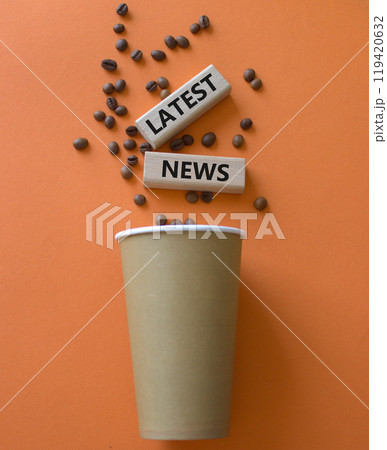Latest News symbol. Concept word Latest News on wooden blocks. Beautiful orange background with coffee cup. Business and Latest News concept. Copy space 119420632
