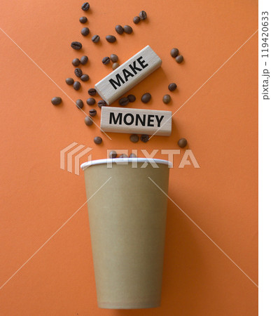 Make Money symbol. Concept word Make Money on wooden blocks. Beautiful orange background with coffee cup. Business and Make Money concept. Copy space 119420633