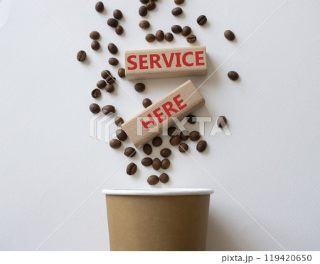 Service here symbol. Concept words Service here on wooden blocks. Beautiful white background with coffee shop and coffee beans. Business and Service here concept. Copy space. 119420650
