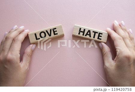 Love vs Hate symbol. Concept word Love vs Hate on wooden blocks. Businessman hand. Beautiful pink background. Business and Love vs Hate concept. Copy space Love vs Hate symbol. Concept word Love vs Hate on wooden blocks. Businessman hand. Beautiful pink background. Business and Love vs Hate concept. Copy space 119420758