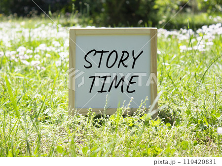 Story Time symbol. Concept word Story Time on white chalk background. Beautiful meadow background. Business and Story Time concept. Copy space Story Time symbol. Concept word Story Time on white chalk background. Beautiful meadow background. Business and Story Time concept. Copy space 119420831