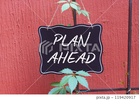 Plan ahead symbol. Concept words Plan ahead on black chalk blackboard. Beautiful red background. Business and Plan ahead concept. Copy space. Plan ahead symbol. Concept words Plan ahead on black chalk blackboard. Beautiful red background. Business and Plan ahead concept. Copy space. 119420917
