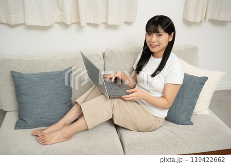 リビングのソファーでパソコンを使う女性 119422662