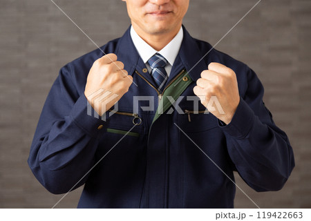 握り拳でガッツポーズをする作業着姿のミドル男性ビジネスマン 119422663
