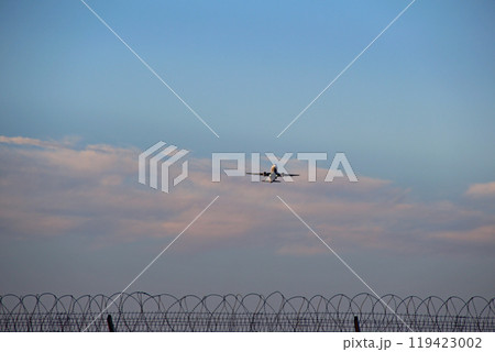 Takeoff Of A Passenger Airliner Over The Fence With Barbed Wire 119423002