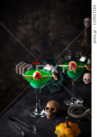 Eerie green Halloween cocktails with skulls 119423164
