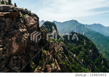 Majestic mountain landscape in Seoraksan National Park showcasing lush greenery and rocky cliffs under a clear blue sky 119423433
