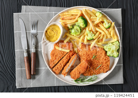 breaded pork cutlet with fries, broccoli on plate 119424451