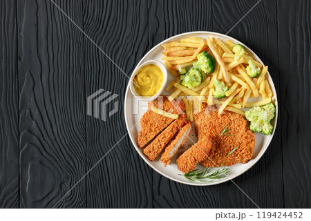 breaded pork cutlet with fries, broccoli on plate 119424452