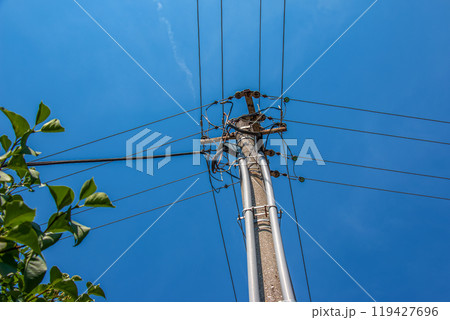 Electric pole power lines outgoing electric wires againts on cloud blue sky. 119427696