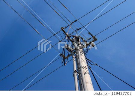 Electric pole power lines outgoing electric wires againts on cloud blue sky. 119427705
