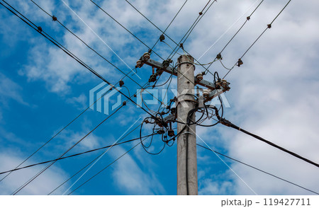 Electric pole power lines outgoing electric wires againts on cloud blue sky. 119427711