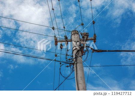 Electric pole power lines outgoing electric wires againts on cloud blue sky. 119427712