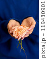 Close-up of a young woman holding a green flower 119430901