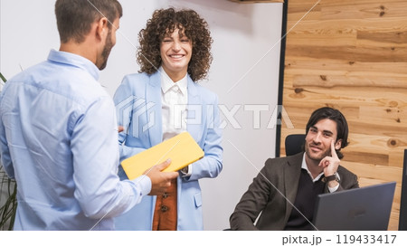 Cheerful businesswoman looking at male colleague during presentation in office Cheerful businesswoman looking at male colleague during presentation in office 119433417