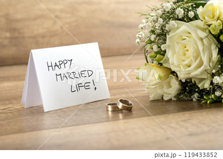 Close up of Beautiful Bride Bouquet of Fresh Flowers, Pair of Rings and Happy Married Life Card Close up of Beautiful Bride Bouquet of Fresh Flowers, Pair of Rings and Happy Married Life Card 119433852