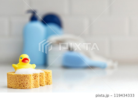 Yellow rubber duck, soap, bath foam on bath background, children bath accessories 119434333