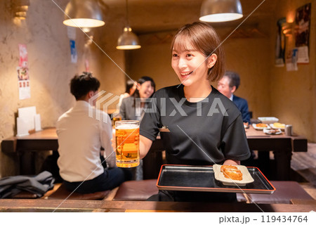 ビールを提供する居酒屋の女性スタッフ 119434764