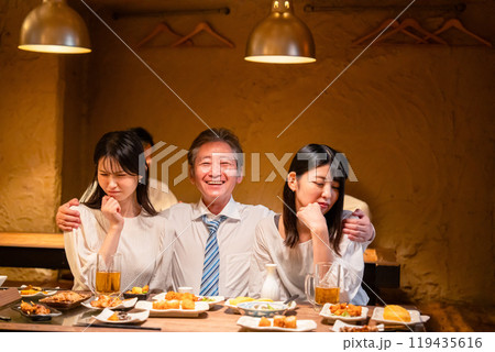 宴会の席で女性と肩を組むビジネスマン 119435616