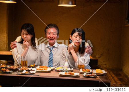 宴会の席で女性と肩を組むビジネスマン 119435621
