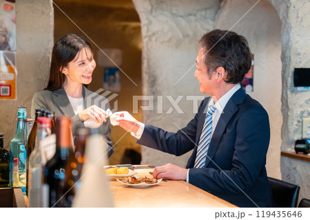女性とお酒を飲むシニアのビジネスマン 女性とお酒を飲むシニアのビジネスマン 119435646