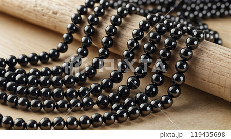 shiny and clean hematite beads on wooden background, close up photo.  119435698