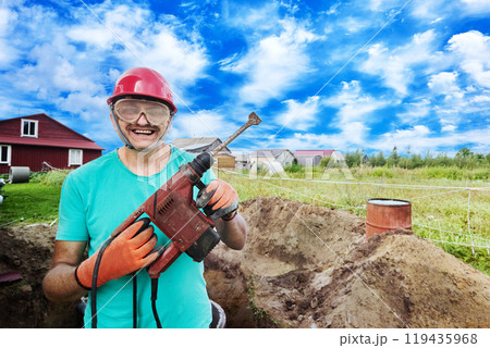 Cheerful construction worker with hammer drill in his hands. Cheerful construction worker with hammer drill in his hands. 119435968