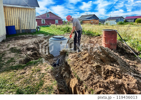 Worker buries an absorbent trench of wastewater disposal area of rural domestic sewage system. Worker buries an absorbent trench of wastewater disposal area of rural domestic sewage system. 119436013