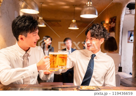 居酒屋でビールを飲む二人の若手ビジネスマン 119436659