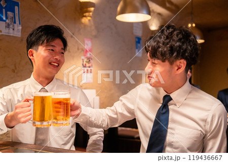 居酒屋でビールを飲む二人の若手ビジネスマン 119436667