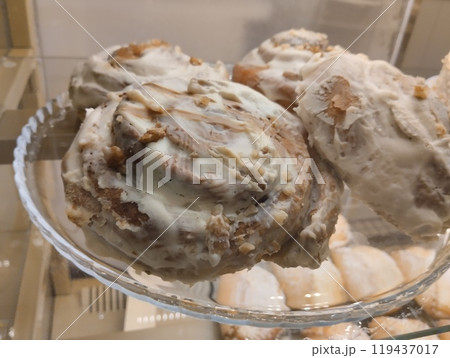 Cinnamon rolls with cream . Three cream buns lying on a plate in a cafe shop window 119437017