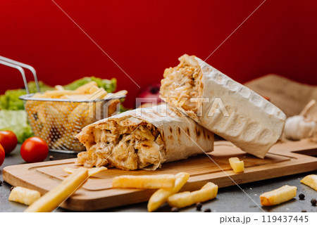Juicy grilled wrap with chicken, fries, and garlic sauce. Perfect for a quick and tasty meal Juicy grilled wrap with chicken, fries, and garlic sauce. Perfect for a quick and tasty meal 119437445