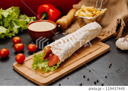 Grilled sausage wrap with fresh lettuce, a perfect quick snack or meal for on-the-go moments Grilled sausage wrap with fresh lettuce, a perfect quick snack or meal for on-the-go moments 119437448