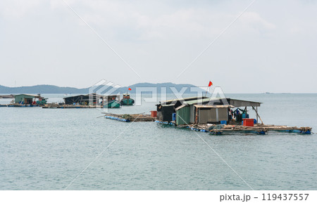 Vietnamese houses on the water, fish farms and fishing boats on the background of tropical islands Vietnamese houses on the water, fish farms and fishing boats on the background of tropical islands 119437557