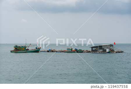 Vietnamese houses on the water, fish farms and fishing boats on the background of tropical islands Vietnamese houses on the water, fish farms and fishing boats on the background of tropical islands 119437558