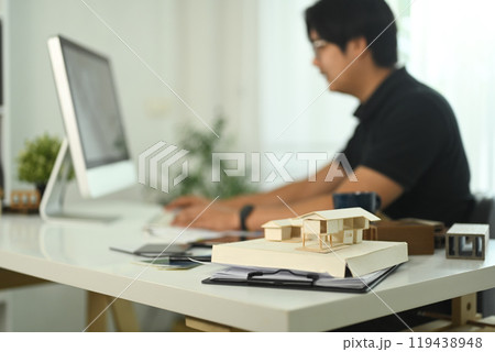 A small house model and documents on an architect workspace A small house model and documents on an architect workspace 119438948