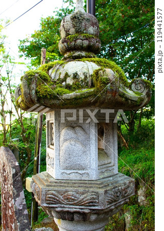 神社の参道に建つ苔むした灯篭 神社の参道に建つ苔むした灯篭 119441577