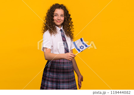 Girl in school uniform holding Israeli flag Girl in school uniform holding Israeli flag 119444082