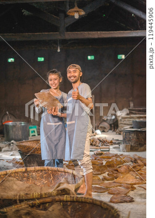 Cheerful artisans proudly showcasing their traditional craft within a vibrant workshop Cheerful artisans proudly showcasing their traditional craft within a vibrant workshop 119445906