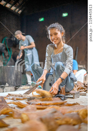 A young artisan skillfully crafting beautiful pieces in a vibrant, colorful workshop 119445913