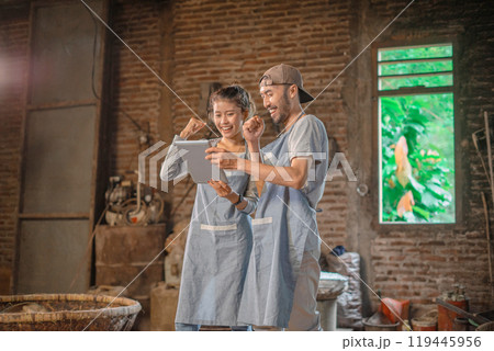 Excited Team Celebrates Success in Artisan Workshop with Digital Tablet Excited Team Celebrates Success in Artisan Workshop with Digital Tablet 119445956