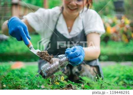 crop view woman hand fills recycled bottle with soil 119446291