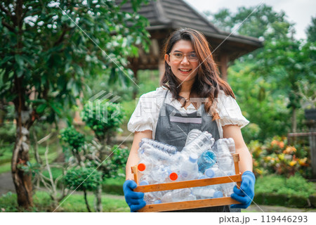 asian woman holding wooden storage full of plastic bottle outdoor 119446293