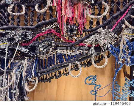 A ropes piece of art is displayed on a wooden wall 119446409