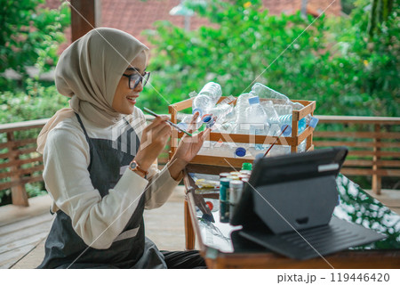 hijab woman making recycled plastic bottle craft hijab woman making recycled plastic bottle craft 119446420