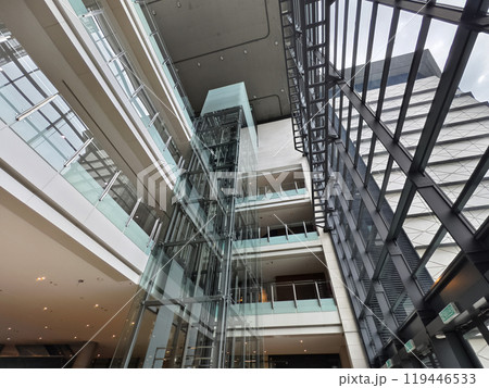 A modern tall building that features a significant amount of glass A modern tall building that features a significant amount of glass 119446533
